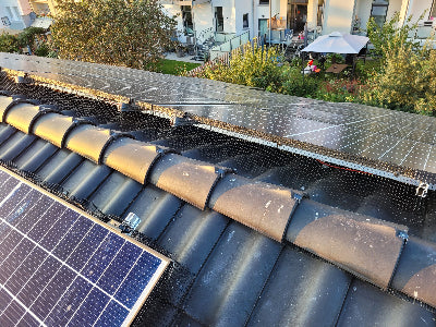 Photovoltaikanlage mit montiertem Solarkäfig. Von Kunden bereitgestellt, zeigt langlebigen und unauffälligen Taubenschutz.